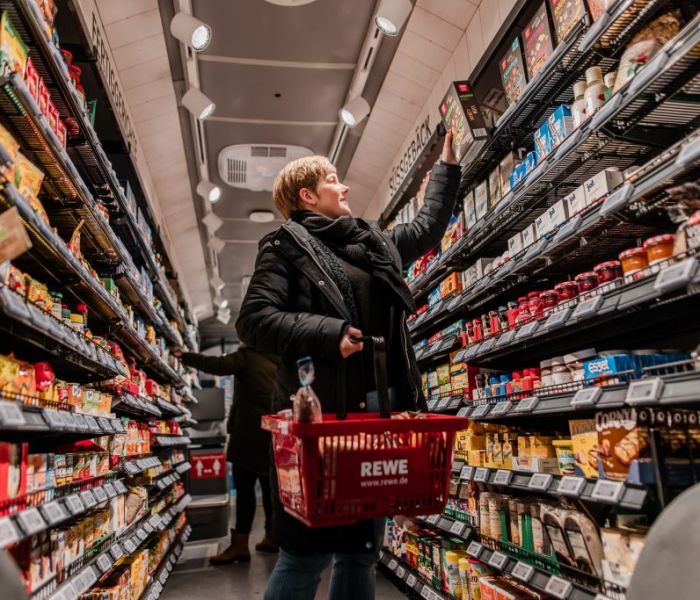 Eine Kundin erledigt ihre Einkäufe im REWE-Einkaufs-Bus. (Foto: REWE)